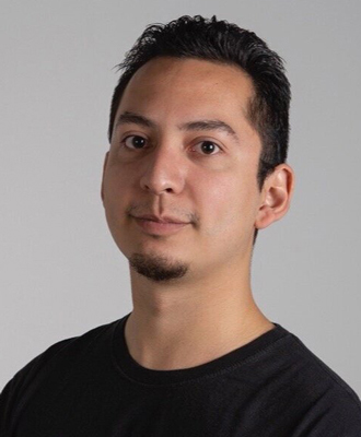 Juan smiling at the camera, short dark hair, black shirt