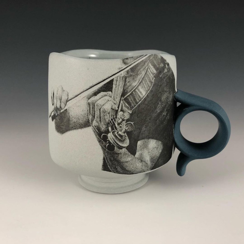 Ceramic cup showing the hands playing a violin