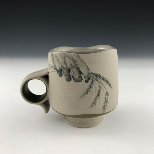 Ceramic cup with a painting of a hand holding wheat stalks