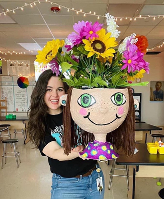 Keisha holding a papier mache flower pot 