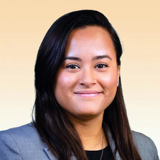 Renee facing forward, smiling, long dark hair, gray jacket, black top