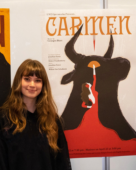 Brennah standing next to her winning poster for the Carmen opera poster competition