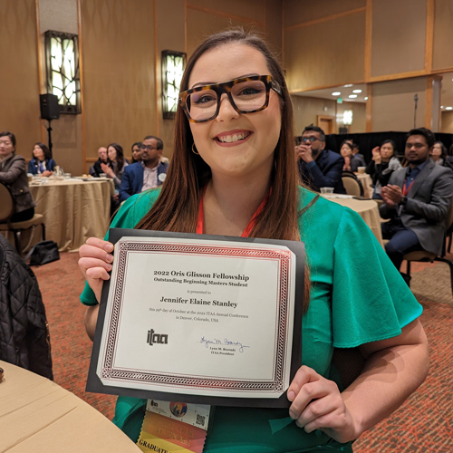 Jennifer Stanley holding up her certificate as the Oris Glisson Fellow for 2022