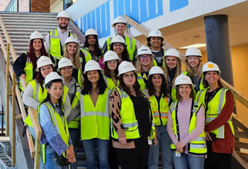 Group of interior design students in yellow safety vests and white hard hats