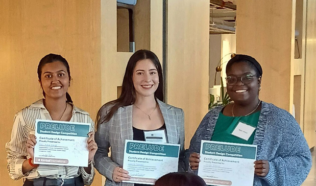 Three students holding of certificates of achievement.