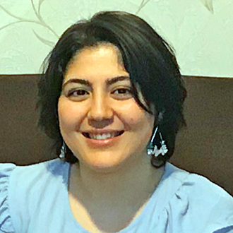 Nouri Soula facing forward smiling, short dark hair, blue shirt