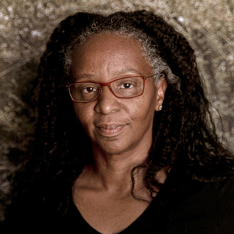 Leticia smiling at the camera, long dark hair, wearing glasses