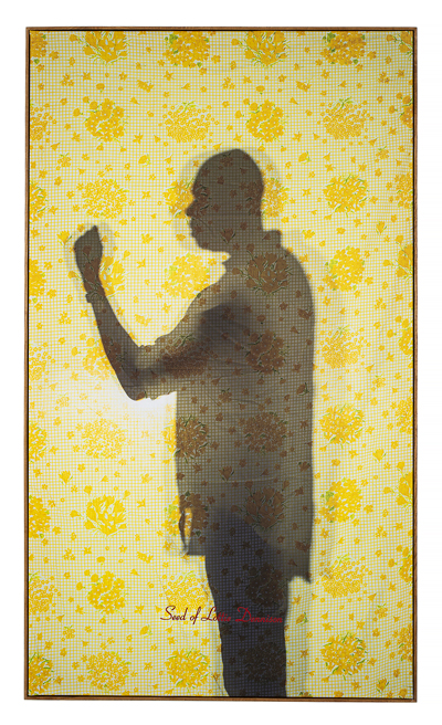 Framed art of the silhouette of Mr. Dennison in profile against a yellow floral print.