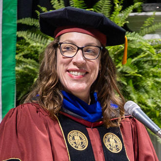 Karen Hutzel facing forward looking to her right, wearing academic regalia.