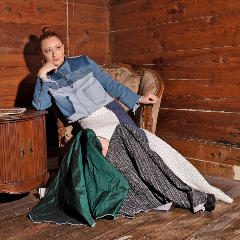 Woman lounging on a chaise modeling a denim design.