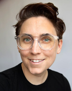 Liss LaFleur smiling, looking at the camera, short dark hair, wearing glasses