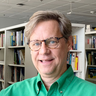 Eric Ligon smiling, brown hair, green shirt