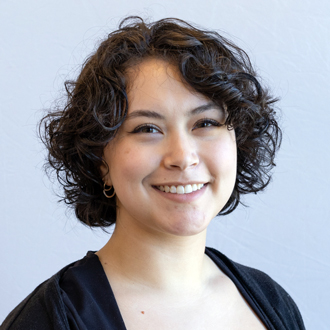 Kara McKintosh facing forward, smiling, short curly hair, black top