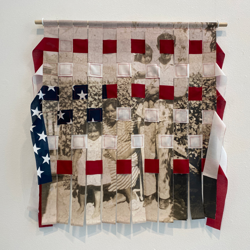 large woven work, warp has American flag, weft has photo of a family in front of a farm field