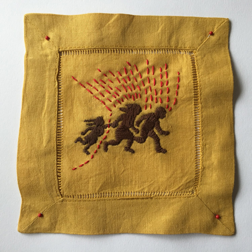 Linen napkin dyed golden brown with embroidery of three people running.
