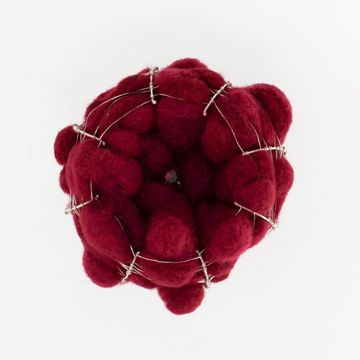 Maroon-colored cotton balls in a round frame of silver