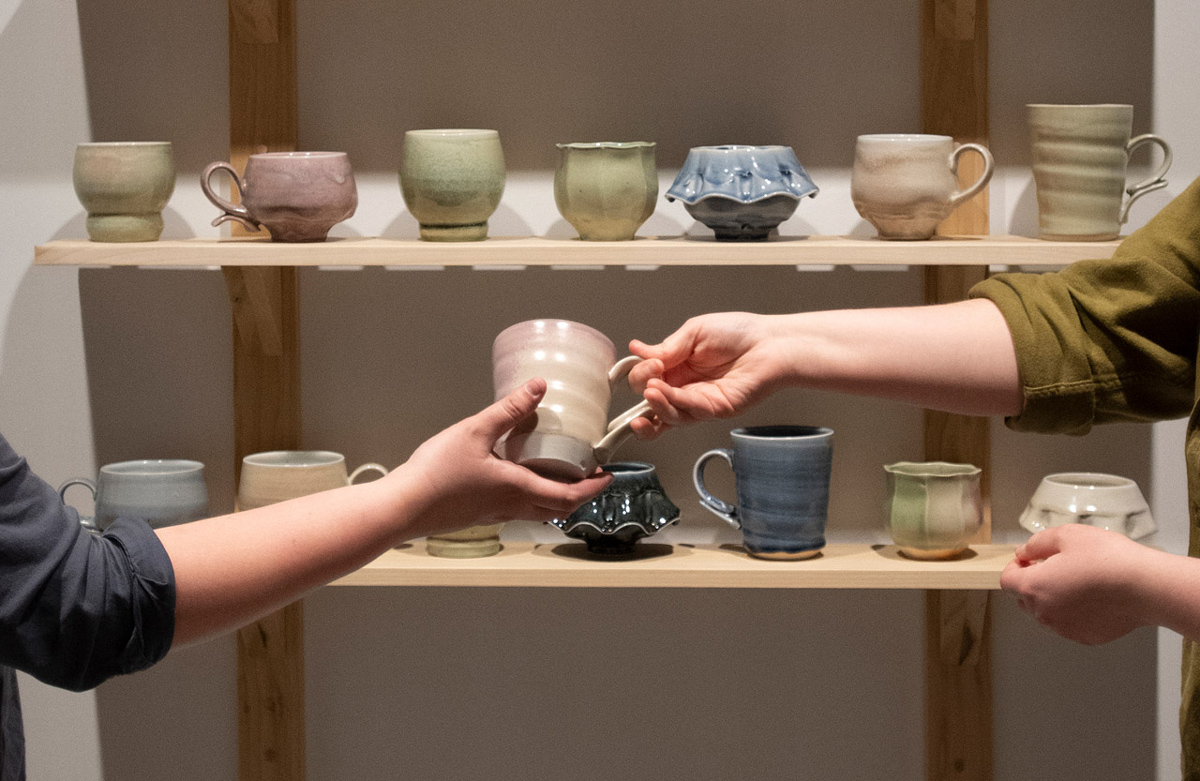 Gallery Installation of Cabinet of Mugs and Cups, with interaction of people