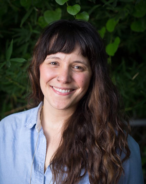 Katherine Sobering looking at the camera, smiling, long brown hair