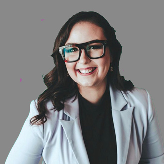 Jennifer Stanley smiling, long hair, glasses, dark top, light gray jacket.