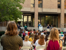 Debbie Stafford speaking at the podium in the UNT Art Building Courtyard