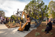 Matthew Ritchie taking a picture of countertenor Daniel Bubeck and harpist Ruth Mertens performing at the dedication of the "Shadow Garden" sculpture.