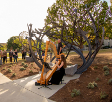 The crowd watches as countertenor Daniel Bubeck and harpist Ruth Mertens performing at the dedication of the "Shadow Garden" sculpture.