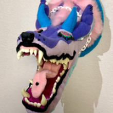 pink, blue and purple stuffed wolf face baring its teeth