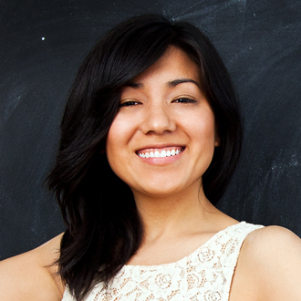 Dana smiling at the camera, shoulder-length dark hair, white top