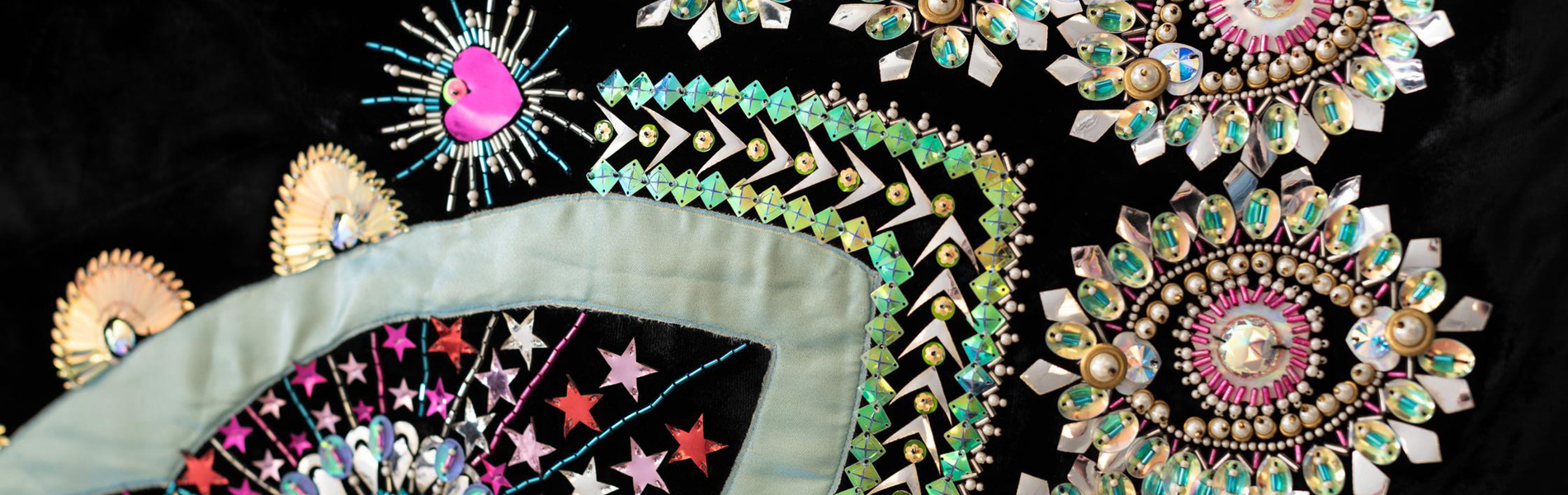 Detail of colorful sequins embroidered on a dark blue gown.