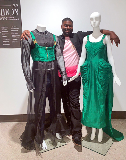 Christian Thornton posing with two designs on mannequins