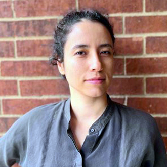 Nasrin 3/4 view, gray shirt, red brick background