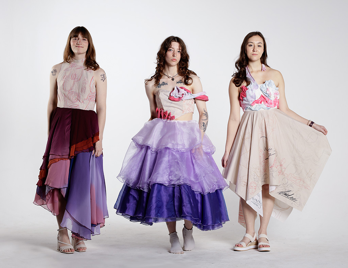 Three models wearing dresses made of custom printed cotton, pastel tie-dyed gauze, ombre chiffon, and three varying shades of purple organza.