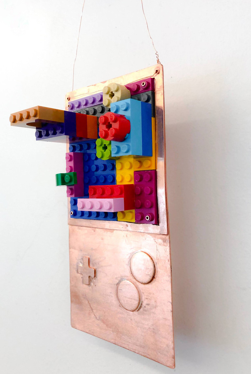 Metal hanging sculpture that incorporates colorful Legos.